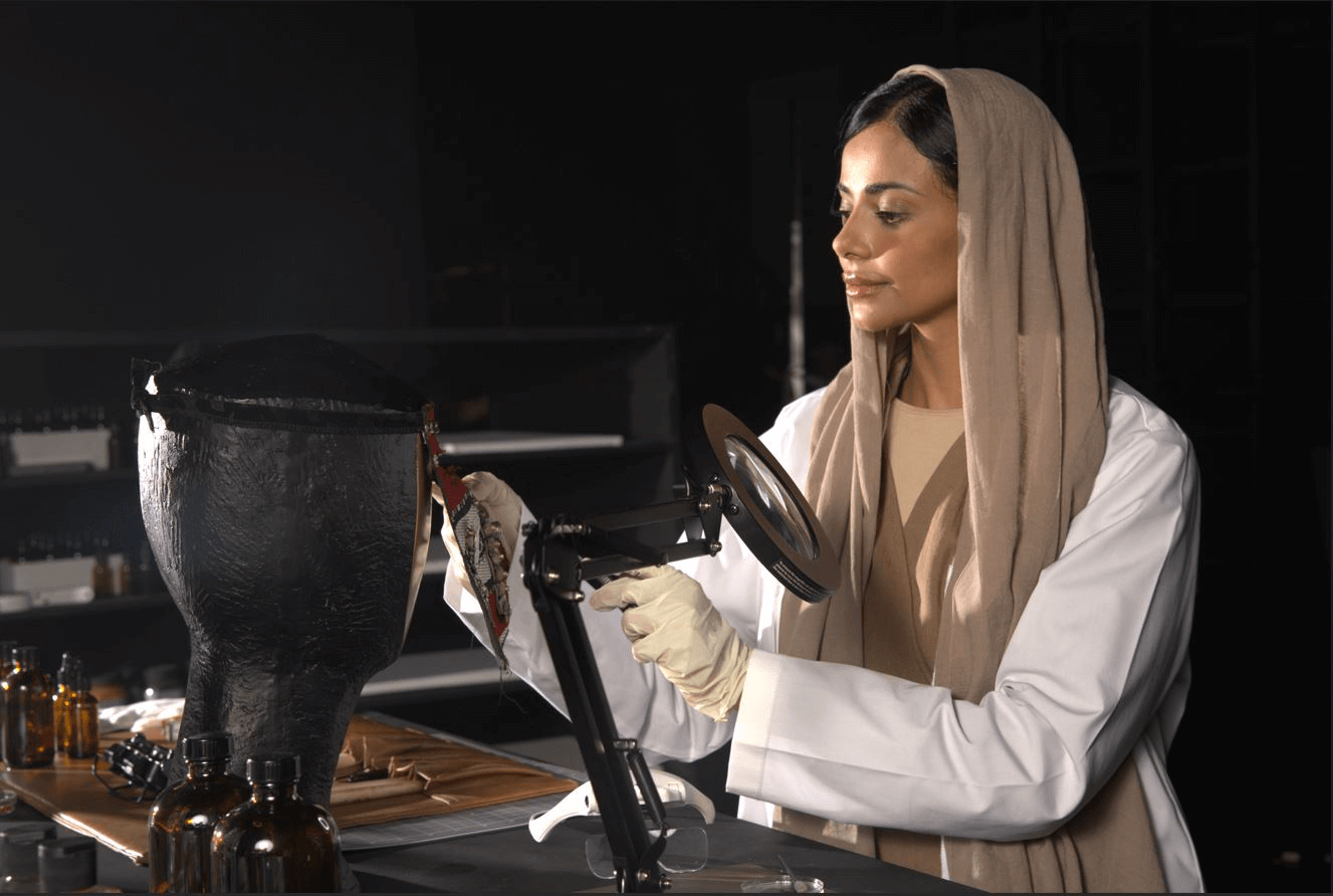 Woman in lab coat conducting research with magnifying glass